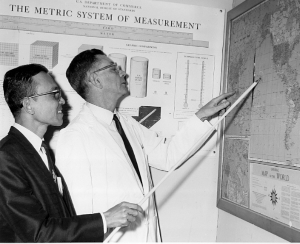 Two men looking at a map. One is using a white stick to point something out