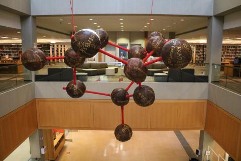 Xiaoman Gu's sculpture called 'Academic Without Borders' hanging in the atrium of University Library